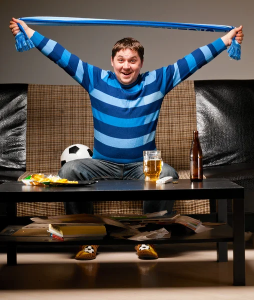 Soccer fan on sofa — Stock Photo, Image