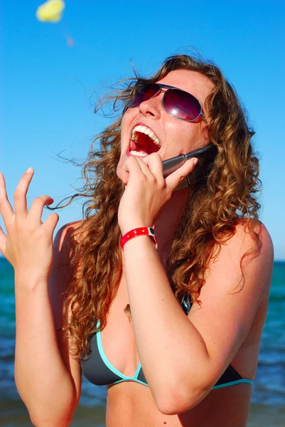 Mulher alegre está falando telefone perto do mar — Fotografia de Stock
