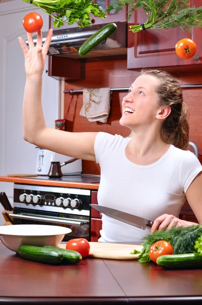 Šťastná žena je na vaření salát z létání zelenina — Stock fotografie