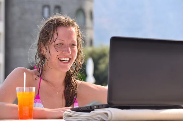 Vrouw is met behulp van laptop van zwembad in de buurt van het hotel — Stockfoto