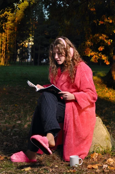 Mujer feliz está leyendo revista en el bosque en desvestirse —  Fotos de Stock