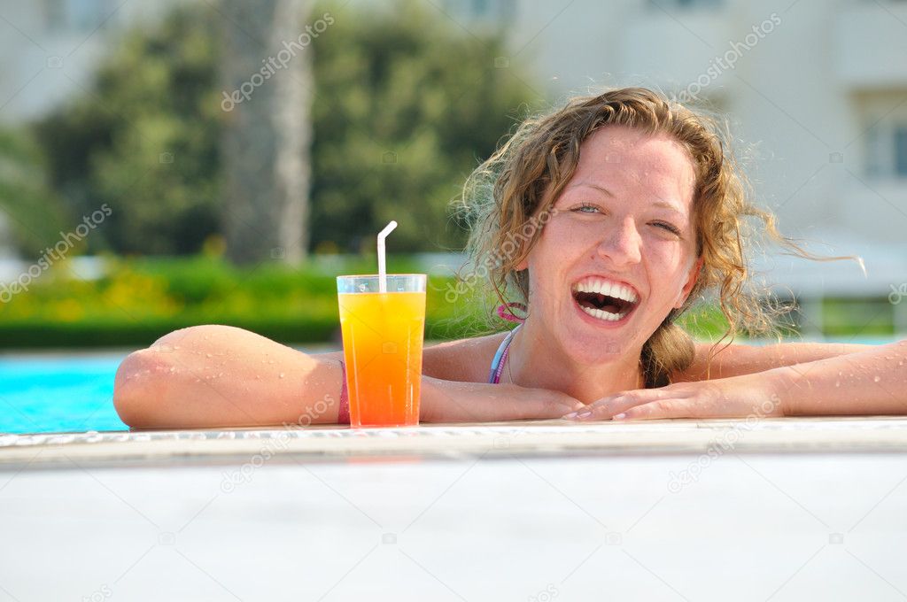 Attractive woman is smiling from swimming pool in resort