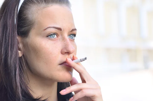 Gros plan d'une jolie femme fumant dans la rue — Photo
