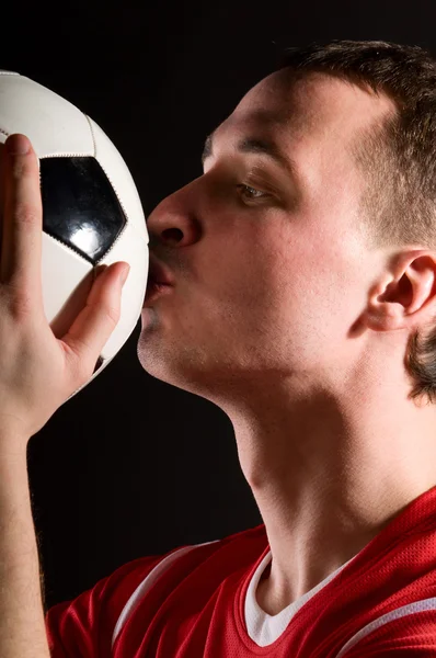 Futbol oyuncusu topu öpüyor — Stok fotoğraf