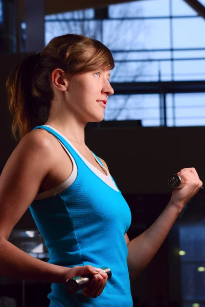 Schöne Frau trainiert abends im Fitnessstudio — Stockfoto
