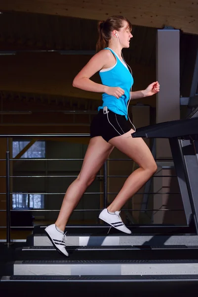 Beautiful woman is running on the treadmill — Stok fotoğraf