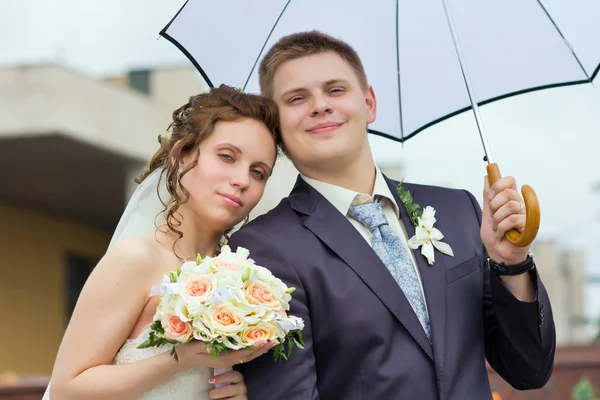 Noiva e noivo sob um guarda-chuva branco — Fotografia de Stock