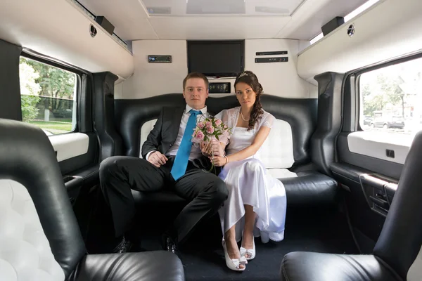 The bride and groom in limousine — Stock Fotó