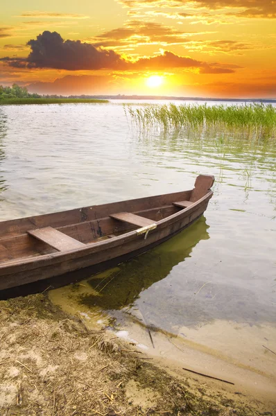 日没に対して海岸でボートします。. — ストック写真