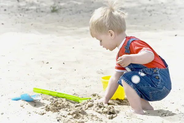 Un bambino gioca a sabbia — Foto Stock