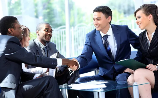 Dois homens de negócios apertando as mãos com sua equipe no escritório — Fotografia de Stock