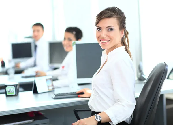 Glad ung affärskvinna ser bakom och hennes kollegor arbetar på kontor — Stockfoto