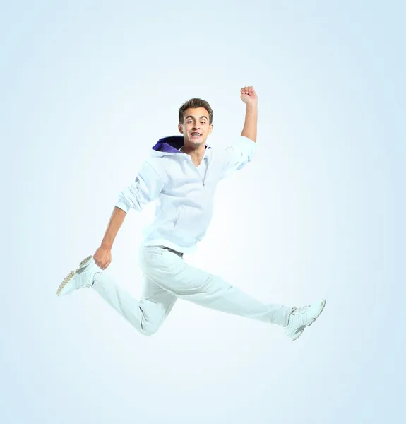跳跃的年轻男子。孤立在蓝色背景 — 图库照片