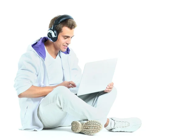 Ung man lyssnar på musik från sin bärbara dator — Stockfoto