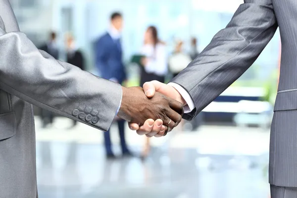 Handshake in front of business — Stock Photo, Image