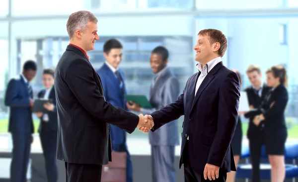 Handshake framför business — Stockfoto