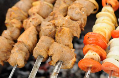 Shish Kebabs, Onion and Tomato Being Cooked on Skewers clipart