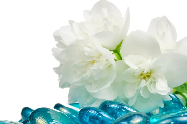 Witte jasmijn bloemen met blauw glas stenen — Stockfoto