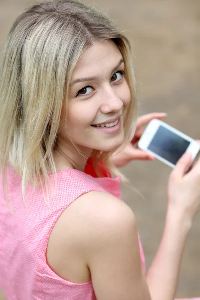 Дівчина відправляє смс зі своїм мобільним телефоном — стокове фото