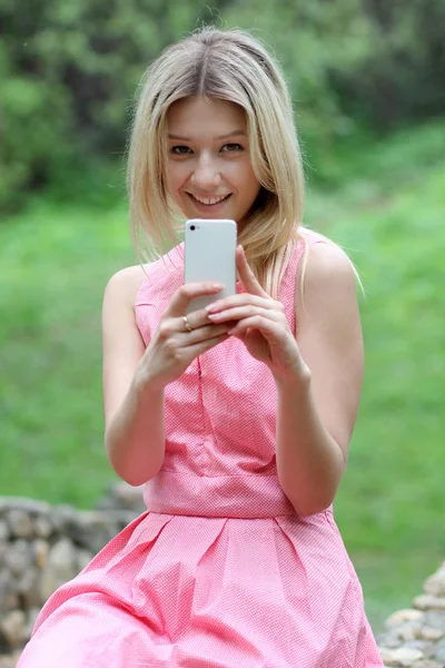 Дівчина відправляє смс зі своїм мобільним телефоном — стокове фото