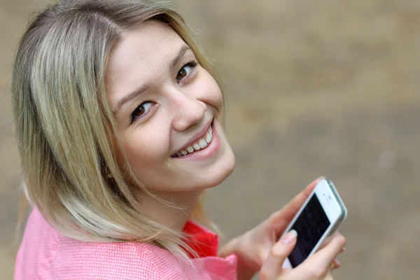 Flicka skicka en sms med sin mobiltelefon — Stockfoto