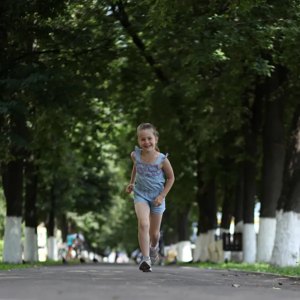 Kleines Mädchen läuft durch den Park — Stockfoto