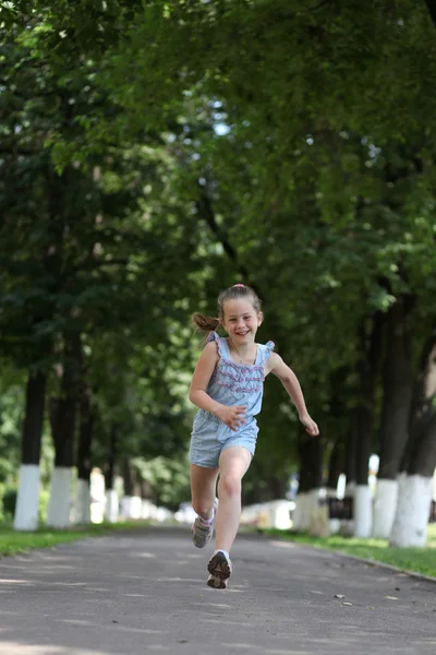 Маленькая девочка бегает по парку — стоковое фото