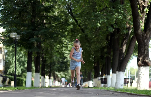 Маленька дівчинка біжить на парку — стокове фото