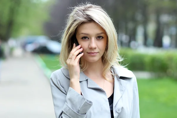 Νεαρή γυναίκα μιλάει στο κινητό τηλέφωνο — Φωτογραφία Αρχείου