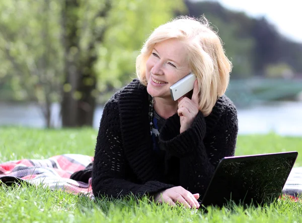 Gelukkig volwassen vrouw bellen via de telefoon — Stockfoto