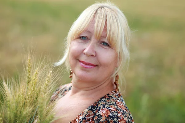 Portrait of an elderly woman in a wheat field — Stock Photo, Image