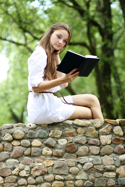 在夏天，绿色公园读的书的年轻女人 — 图库照片