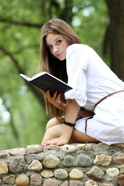 Oung vrouw in de zomer, groen park leesboek — Stockfoto