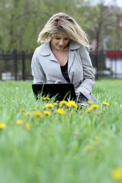 Jovem loira se divertindo com laptop ao ar livre — Fotografia de Stock