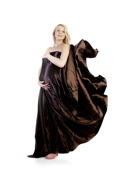 Беременная девушка в длинном коричневом платье — стоковое фото