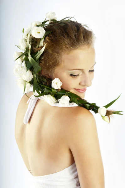 Mulher bonita com flores frescas da primavera em seu cabelo — Fotografia de Stock
