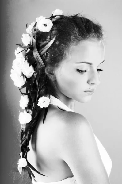 Schöne junge Frau mit frischen Frühlingsblumen im Haar — Stockfoto
