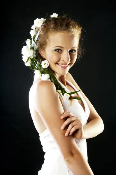 Schöne junge Frau mit frischen Frühlingsblumen im Haar — Stockfoto