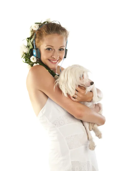 Hermosa chica con auriculares sosteniendo un perro — Foto de Stock