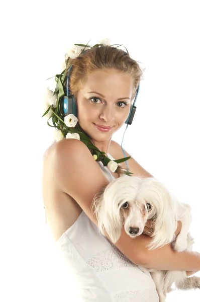 Όμορφη κοπέλα με ακουστικά που κατέχει ένα σκυλί — Φωτογραφία Αρχείου