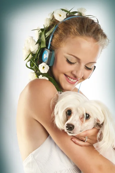 Όμορφη κοπέλα με ακουστικά που κατέχει ένα σκυλί — Φωτογραφία Αρχείου