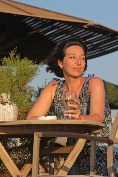 Женщина, сидящая в кафе на открытом воздухе с чашами белого винограда — стоковое фото