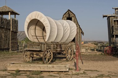 Western covered wagon on yard of Fort clipart