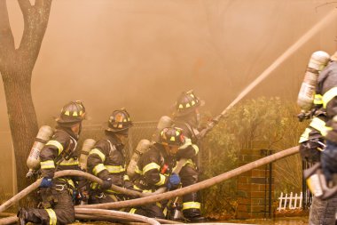 Firemen at work putting out a house fire clipart