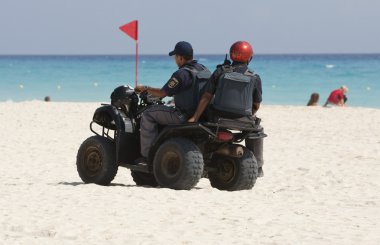 Coast police cheking the beach. clipart