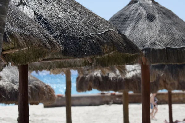 Ombrelli di paglia sulla spiaggia di sabbia — Foto Stock