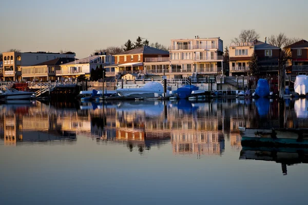 Reflection of coastline buildings in a calm bay — Stock Photo, Image