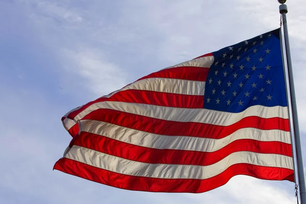 Foto de Stock: Bandera americana contra el cielo azul — Foto de Stock