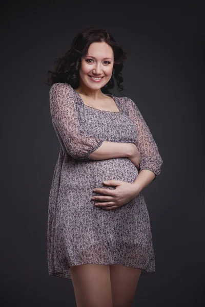 Беременная женщина на тёмном фоне — стоковое фото