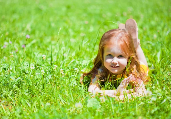 笑顔の女の子は、草原に横たわっています。 — ストック写真